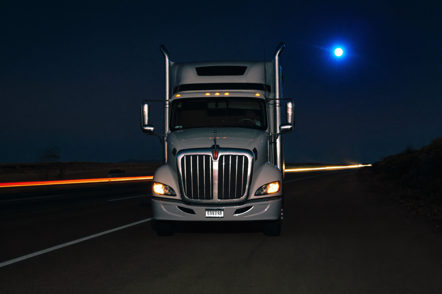 A semi-truck parked awkwardly on a dark highway shoulder at night with hazard lights on, isolated and exposed
